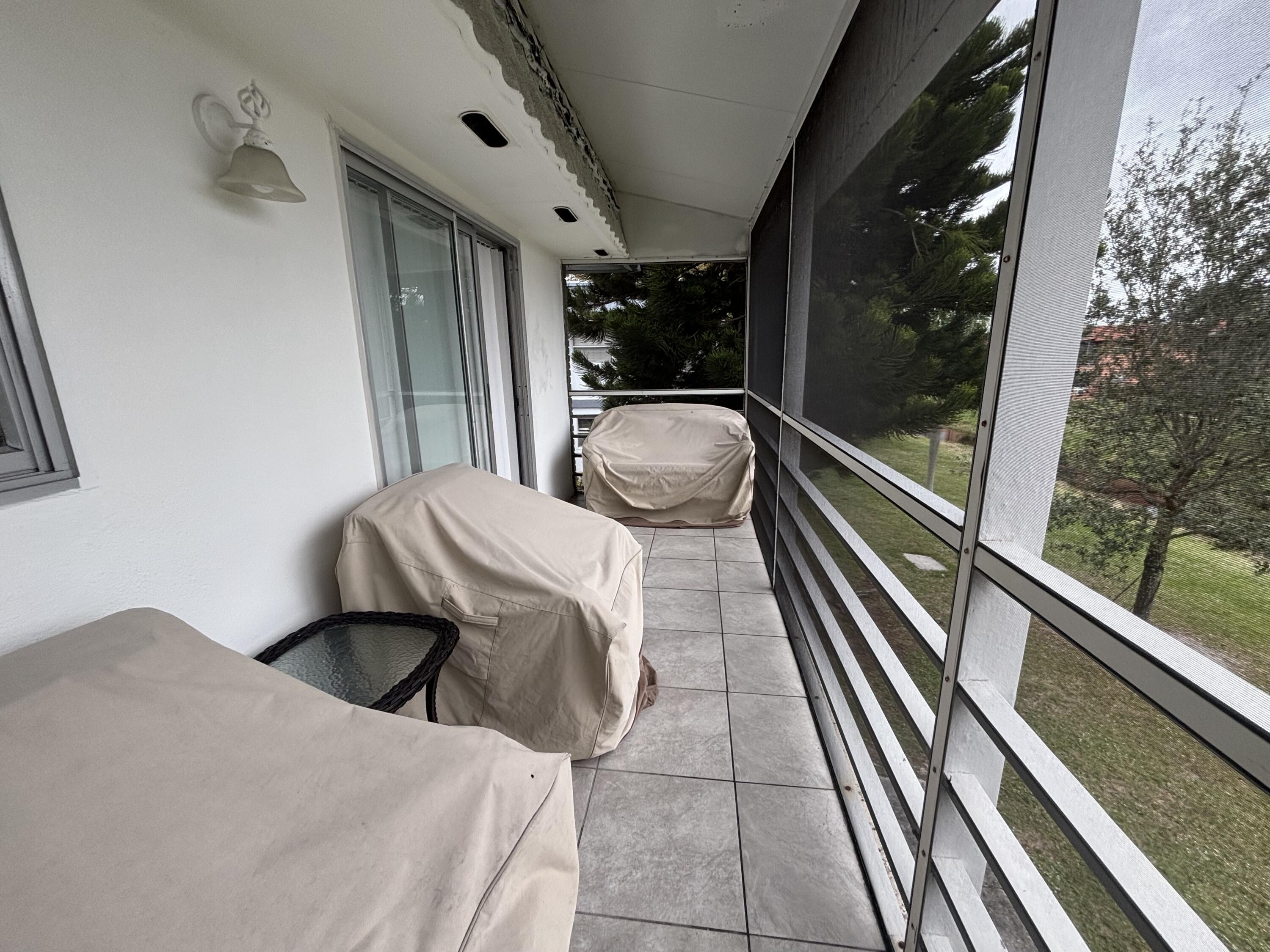 596 Saxony M, Unit 596 Delray Beach, FL 33446 - Photo 17 of 23 a bedroom with a bed and wooden floor