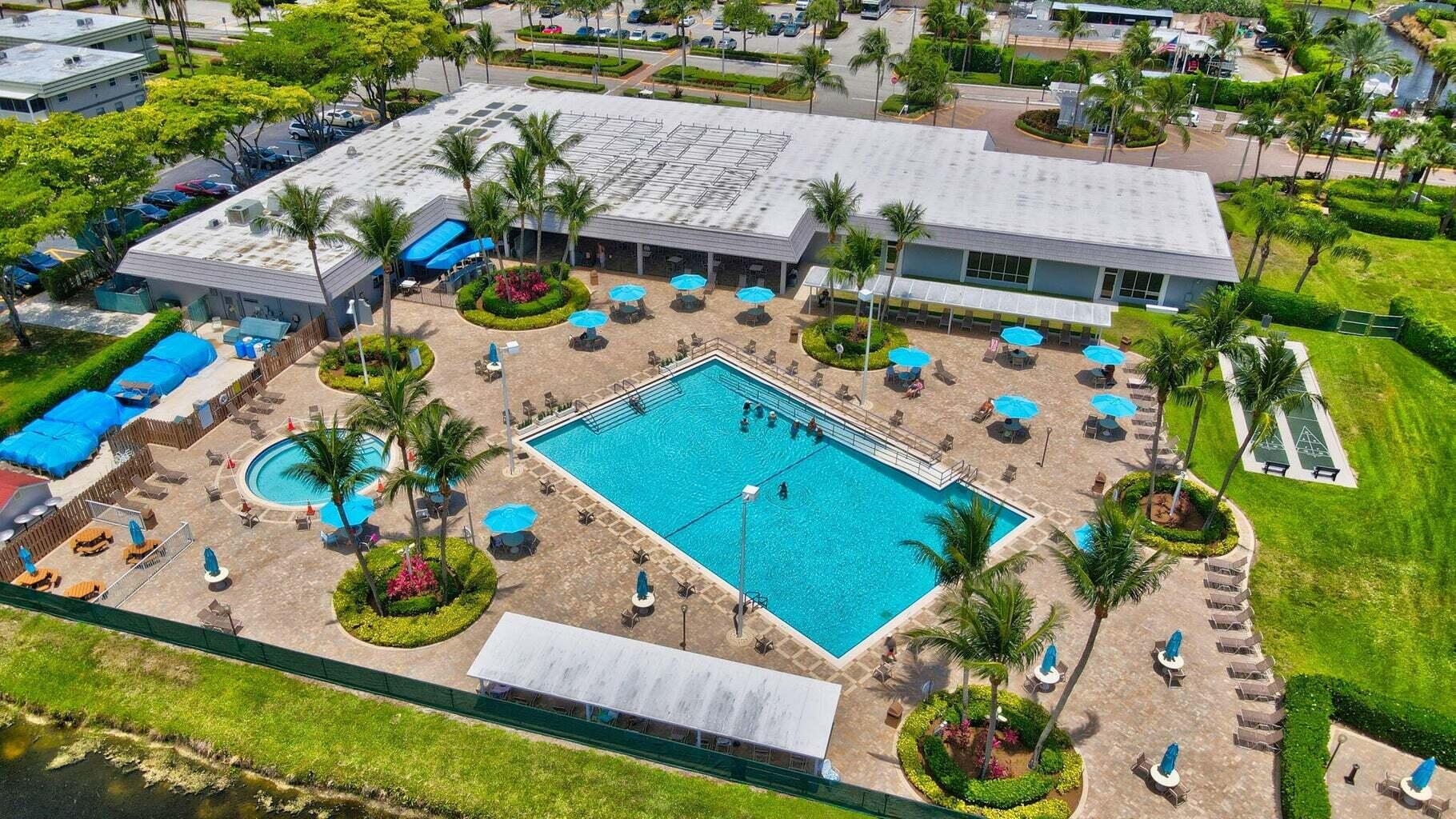 596 Saxony M, Unit 596 Delray Beach, FL 33446 - Photo 20 of 23 an aerial view of an chairs and umbrellas
