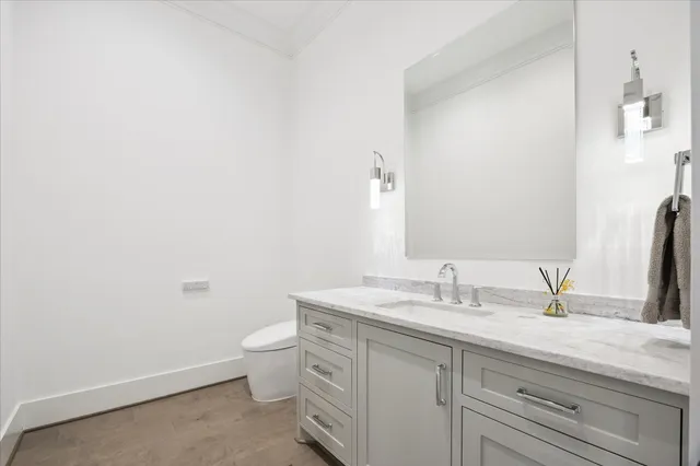 a bathroom with a granite countertop sink a toilet and a mirror