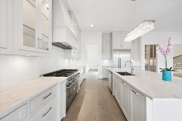 a kitchen with stainless steel appliances granite countertop a sink stove and cabinets