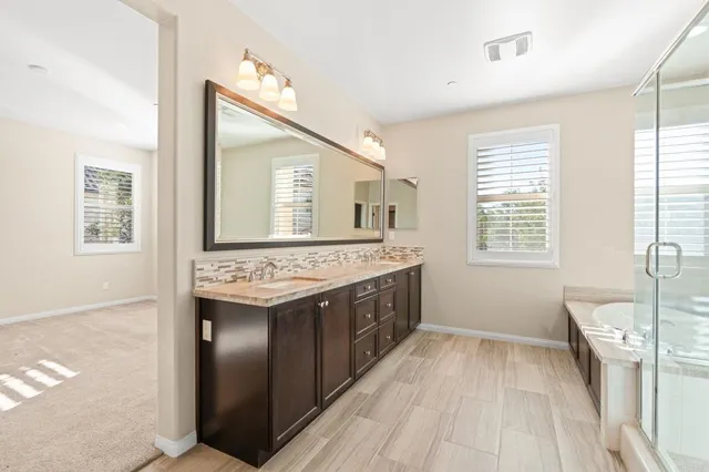 a bathroom with a sink vanity granite and a mirror