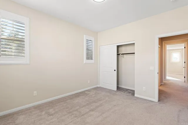 an empty room with windows and closet