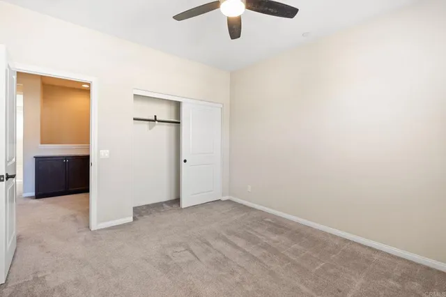 an empty room with closet and windows