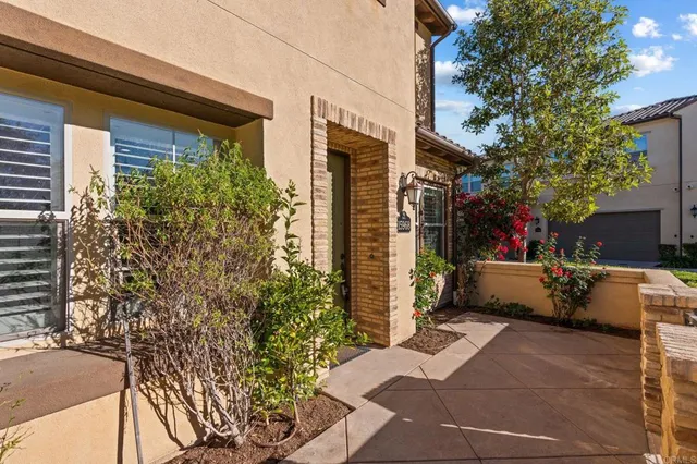a view of a patio with couches and table and chairs under an umbrella