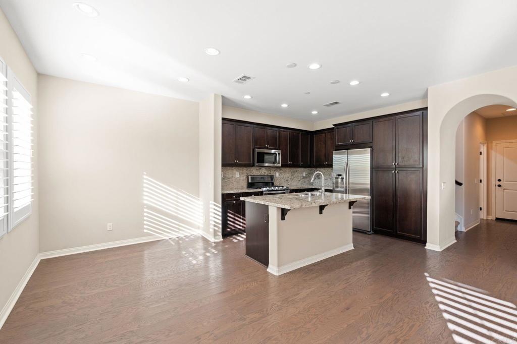 15968 Parkview Loop San Diego, CA 92127 - Photo 7 of 45 a kitchen with stainless steel appliances kitchen island granite countertop a refrigerator and a sink