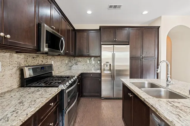 a kitchen with kitchen island granite countertop stainless steel appliances and cabinets