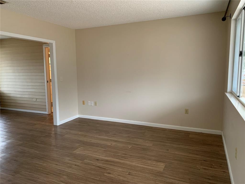 8431 Southwest 109th Lane Road Ocala, FL 34481 - Photo 5 of 20 a view of an empty room with wooden floor and a window