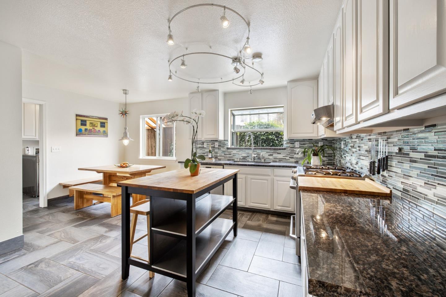 226 Palma Street El Granada, CA 94018 - Photo 13 of 41 a room with stainless steel appliances kitchen island granite countertop a sink and cabinets