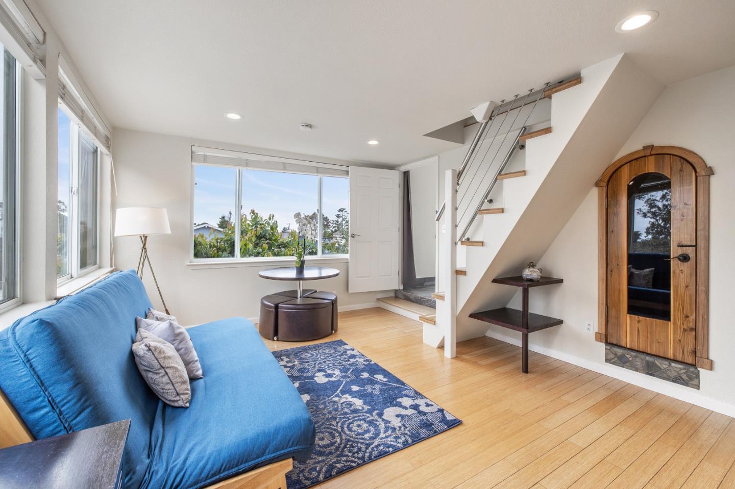 226 Palma Street El Granada, CA 94018 - Photo 19 of 41 a living room with furniture floor to ceiling window and wooden floor