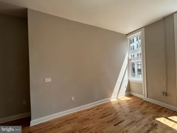 an empty room with wooden floor and entrance