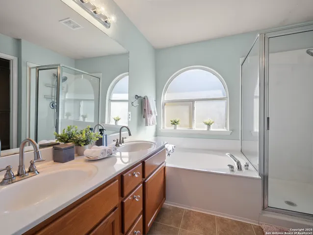 a bathroom with a tub a sink and mirror