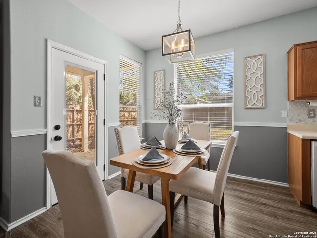 a dining room with furniture a chandelier and wooden floor