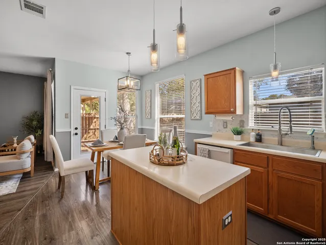 a kitchen with a stove a sink a dining table and chairs
