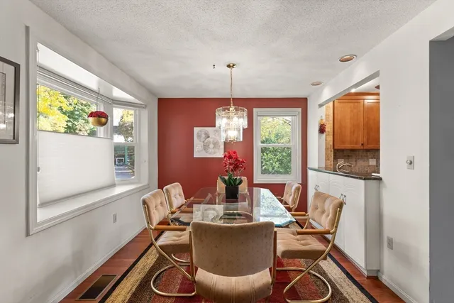 a dining room with furniture a chandelier and wooden floor