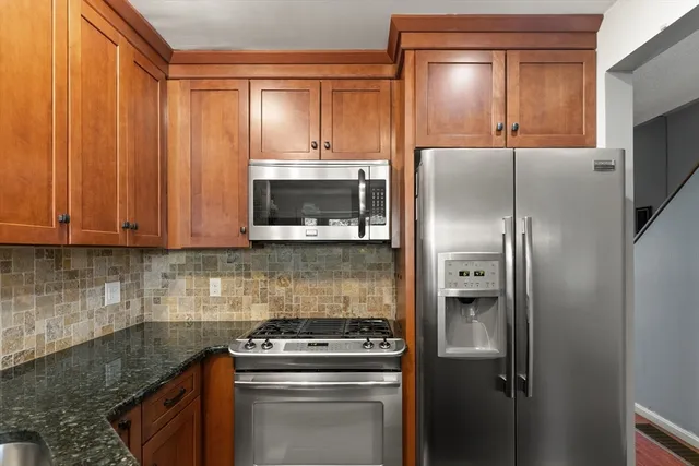 a kitchen with a refrigerator stove and cabinets