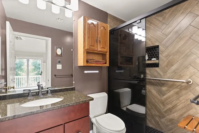 a bathroom with a granite countertop sink toilet and shower