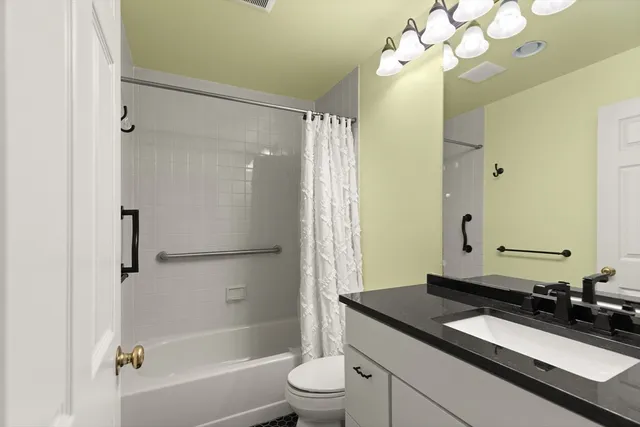 a bathroom with a granite countertop sink a toilet and shower