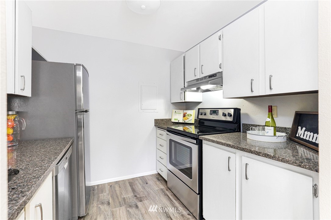 17518 149th Avenue Southeast, Unit 8 Renton, WA 98058 - Photo 12 of 25 a kitchen with granite countertop a sink stove and refrigerator