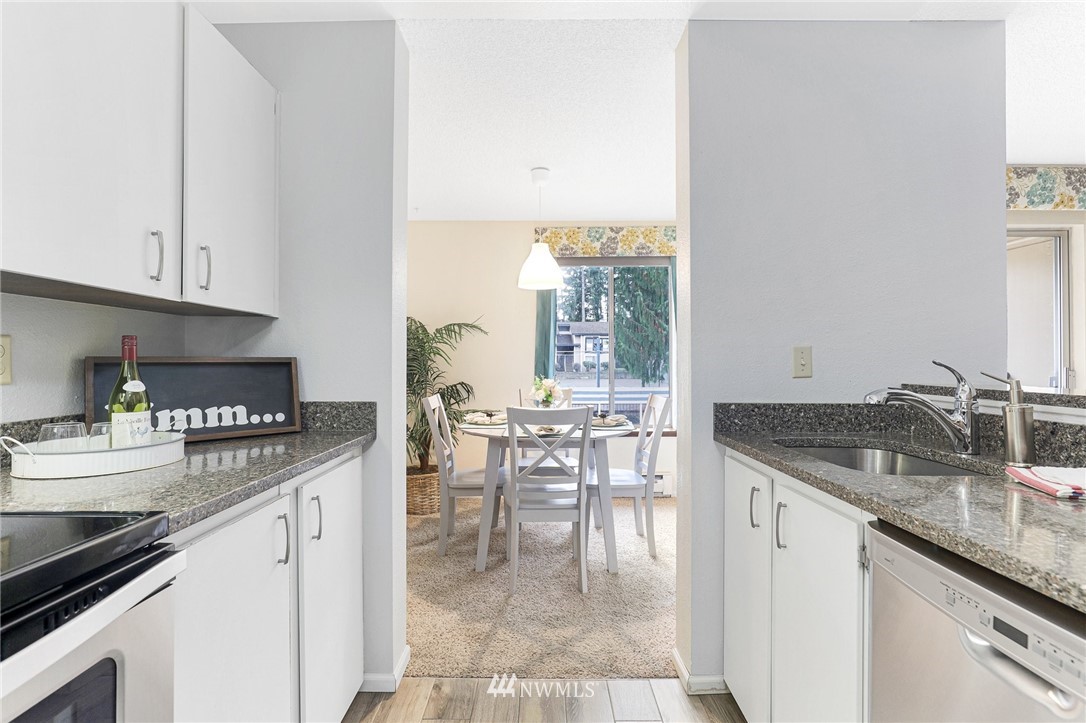 17518 149th Avenue Southeast, Unit 8 Renton, WA 98058 - Photo 13 of 25 a kitchen with granite countertop a sink and cabinets