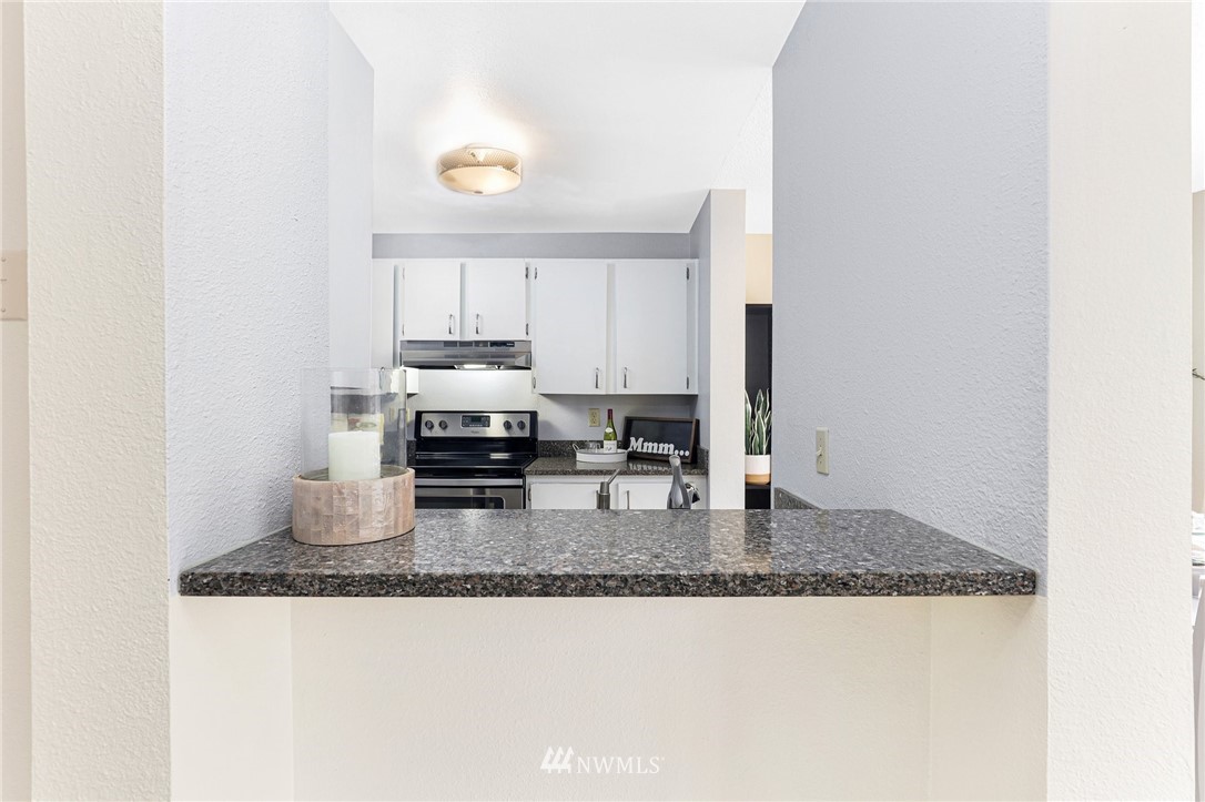 17518 149th Avenue Southeast, Unit 8 Renton, WA 98058 - Photo 5 of 25 a kitchen with granite countertop a sink and a stove top oven