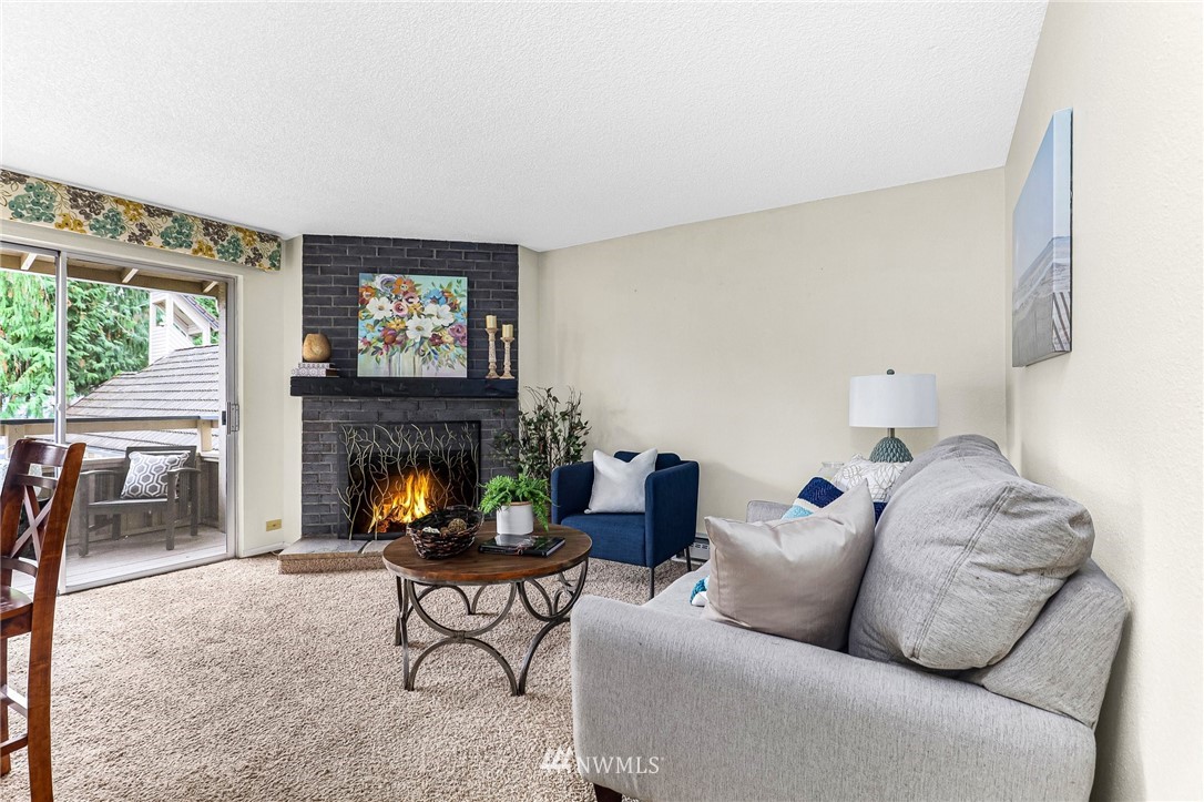 17518 149th Avenue Southeast, Unit 8 Renton, WA 98058 - Photo 6 of 25 a living room with furniture a fireplace and a flat screen tv