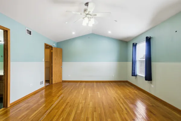 a view of empty room with wooden floor