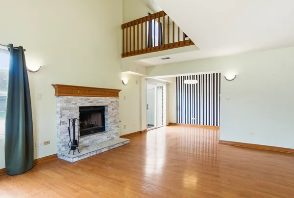 a view of a livingroom with wooden floor and a fireplace