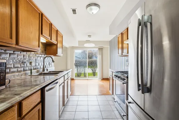 a kitchen with stainless steel appliances granite countertop a refrigerator and a sink