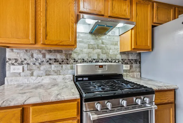 a stove top oven sitting inside of a kitchen