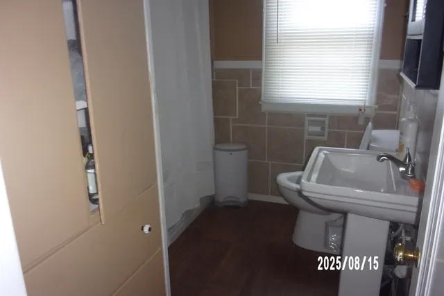 a bathroom with a sink a toilet and a window