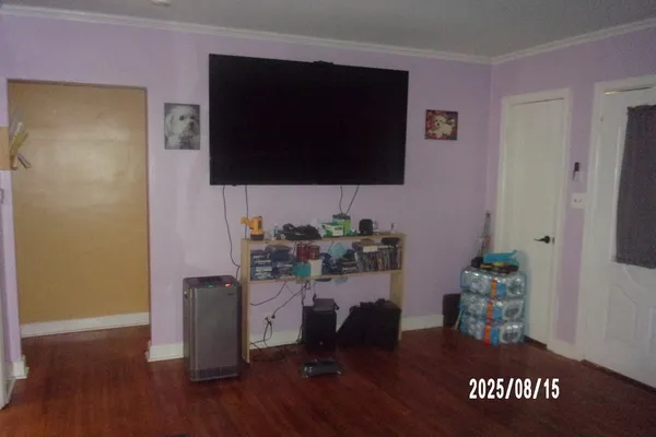 a living room with a wooden floor and a flat screen tv