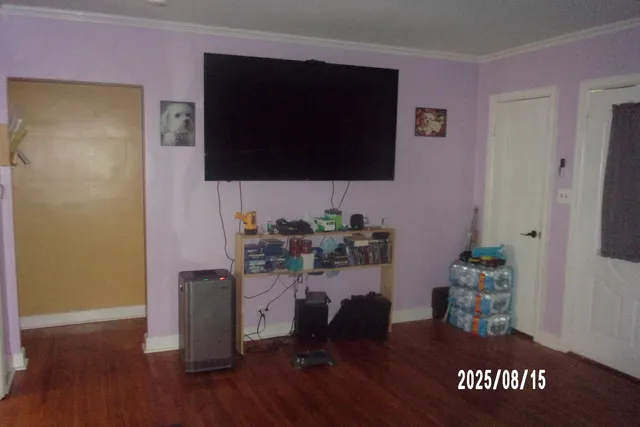 a living room with a wooden floor and a flat screen tv