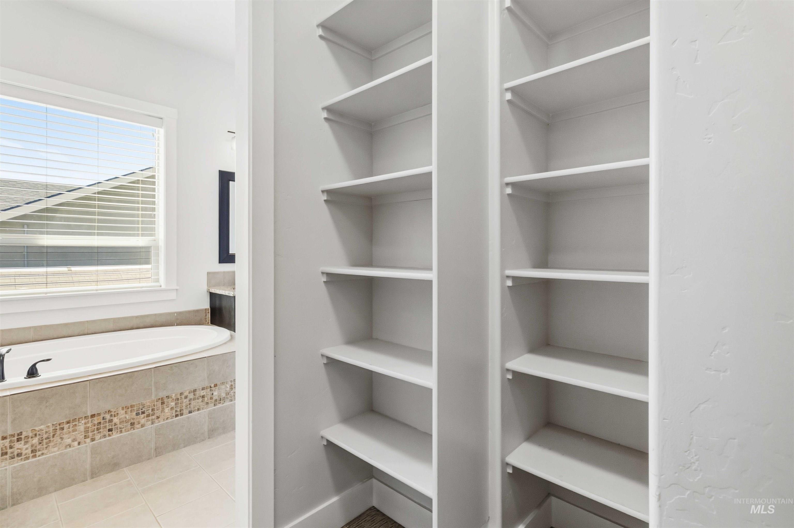 3218 North Cherry Laurel Way Star, ID 83669 - Photo 24 of 50 Walk-in closet featuring built-in shelving, multiple hanging rods, and wood-finish flooring
