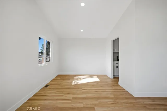a view of empty room with wooden floor