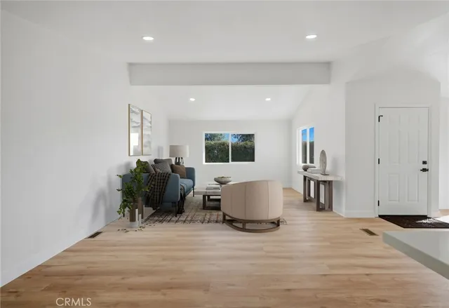 a living room with furniture a window and a table with wooden floor