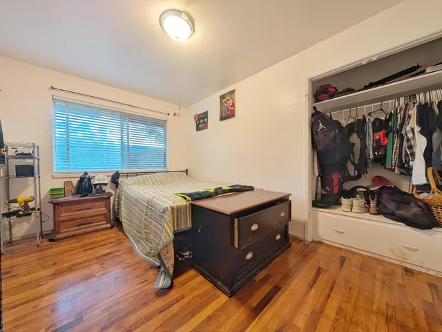 a bedroom with a bed and wooden floor