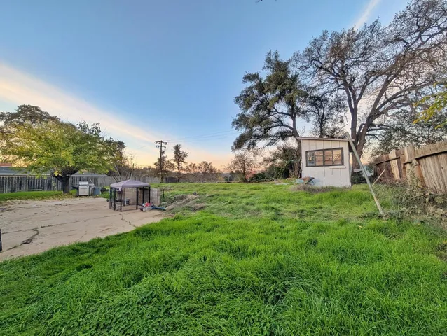 a view of a house with backyard and sitting area