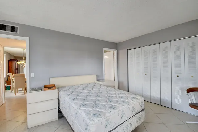 a bedroom with a large bed and wooden floor