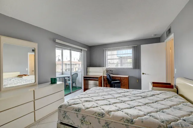 a bedroom with a large bed and wooden floor