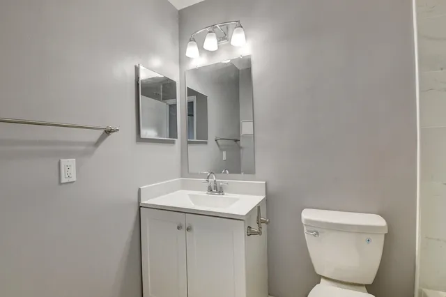 a bathroom with a toilet sink and mirror