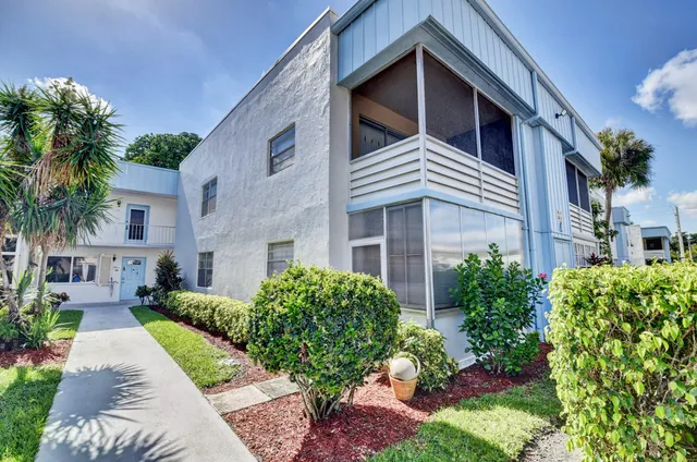 a view of a house with a yard and potted plants