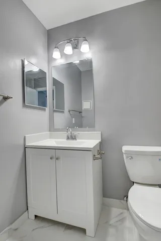 a bathroom with a toilet sink and mirror