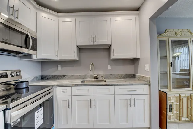 a kitchen with stainless steel appliances granite countertop a sink and a stove