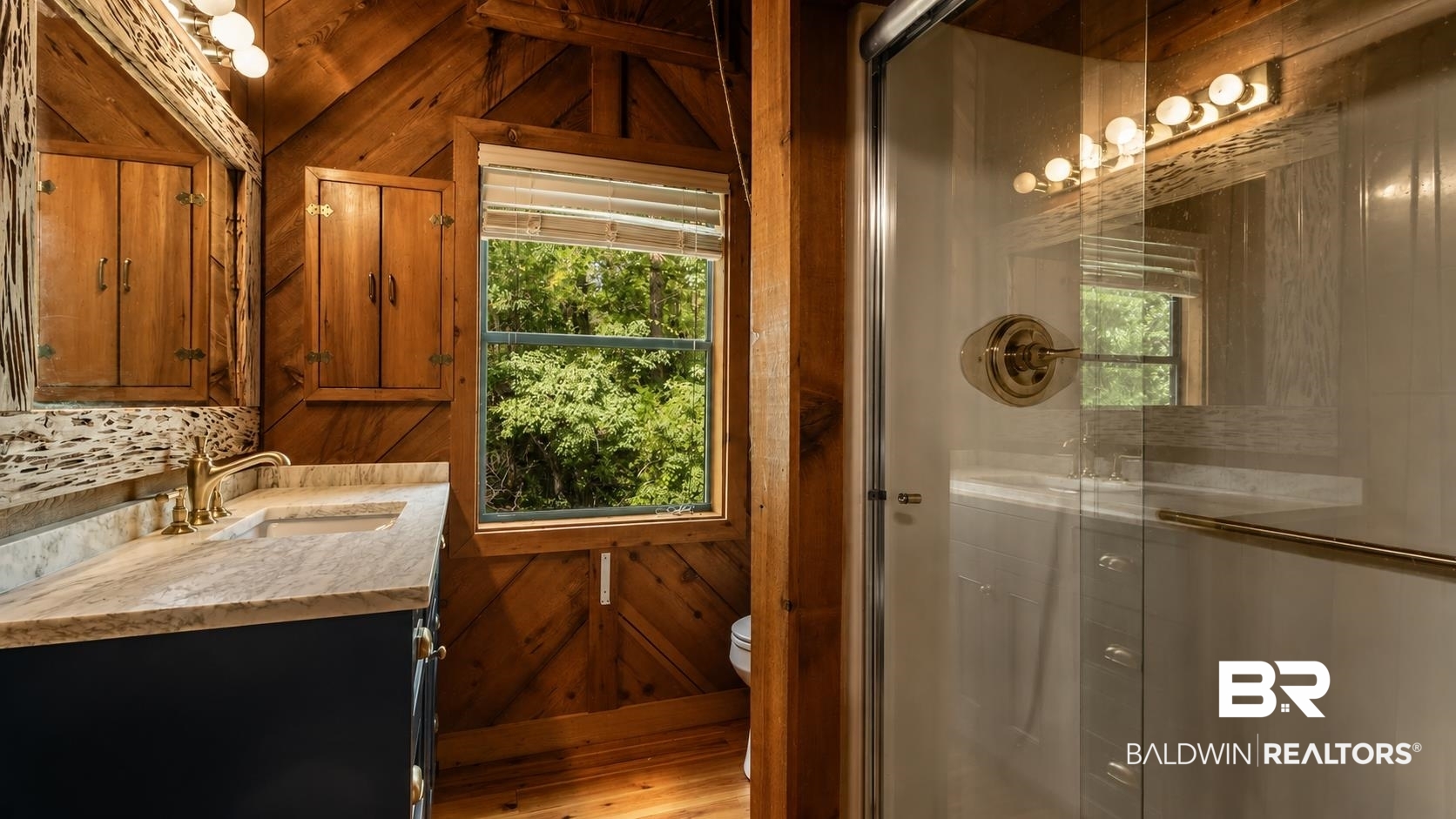 14587 Ridge Road Summerdale, AL 36580 - Photo 32 of 44 Wood-paneled bathroom featuring a vanity with a light-colored countertop, gold-toned faucet, and dark base cabinetry