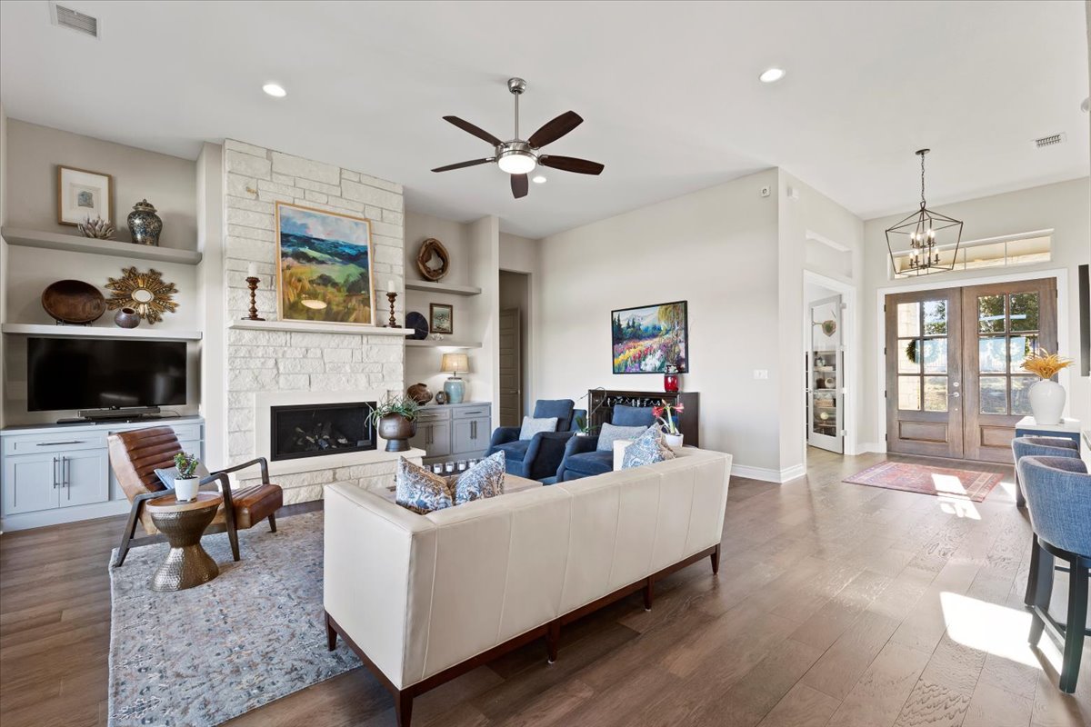 17825 Windecker Cove Dripping Springs, TX 78620 - Photo 21 of 39 a living room with furniture a flat screen tv and a fireplace