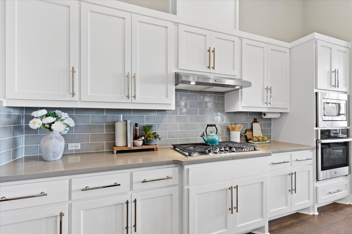 17825 Windecker Cove Dripping Springs, TX 78620 - Photo 24 of 39 a kitchen with white cabinets and white appliances