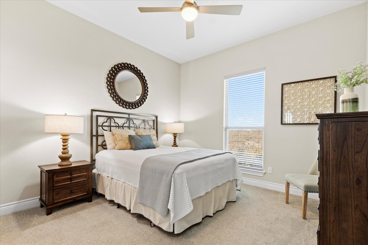 17825 Windecker Cove Dripping Springs, TX 78620 - Photo 27 of 39 a bedroom with a bed and a chandelier