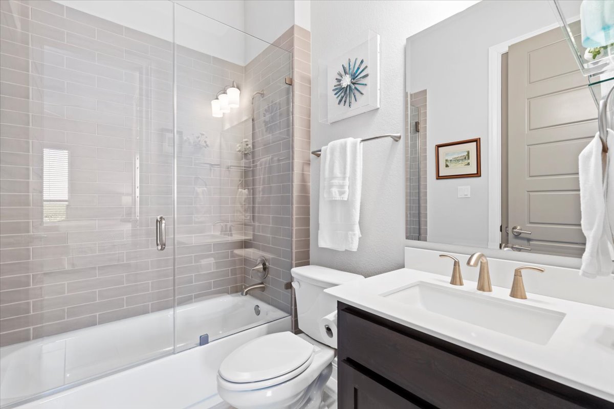 17825 Windecker Cove Dripping Springs, TX 78620 - Photo 28 of 39 a bathroom with a bathtub shower sink vanity mirror and toilet
