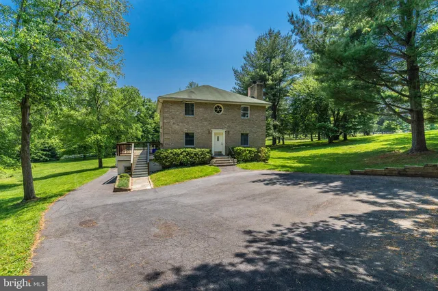 a view of a house with a big yard and large trees