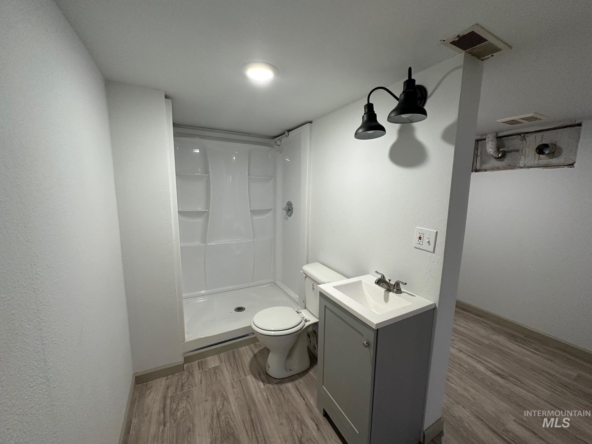 264 Southwest 10th Avenue Ontario, OR 97914 - Photo 17 of 26 Full bathroom with wood finished floors, a stall shower, and vanity